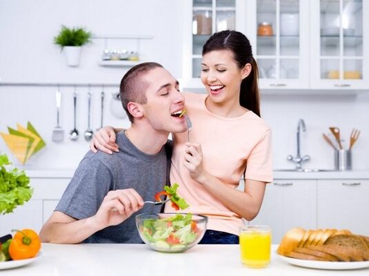 seorang wanita memberi makan seorang pria dengan produk untuk meningkatkan potensi secara alami