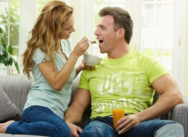 seorang wanita memberi makan seorang pria dengan produk untuk meningkatkan potensi